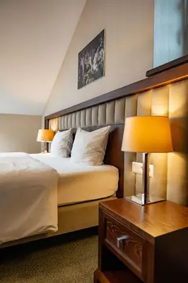 a hotel room with a bed and a table with a lamp at Grand Sal in Wieliczka