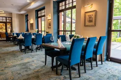 a dining room with tables and blue chairs at Grand Sal in Wieliczka