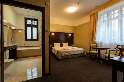 a hotel room with a bed and a bathroom at Grand Sal in Wieliczka