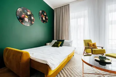 a bedroom with a bed and a green wall at Tomasza 20 Apartments in Kraków
