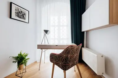 a desk and a chair in a room with a window at Tomasza 20 Apartments in Kraków