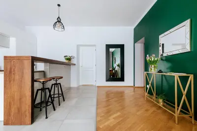 a kitchen and living room with a green wall at Tomasza 20 Apartments in Kraków