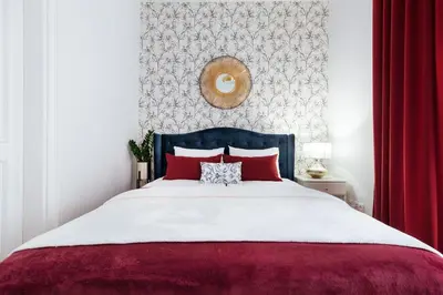 a bedroom with a large bed with red pillows at Tomasza 20 Apartments in Kraków