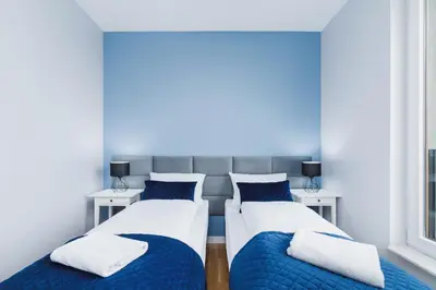 two beds in a room with blue and white at NY Residence Apartments Wrocławska Cracow by Renters Prestige in Kraków