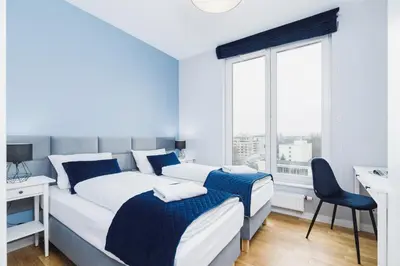 a bedroom with two beds and a desk and a window at NY Residence Apartments Wrocławska Cracow by Renters Prestige in Kraków