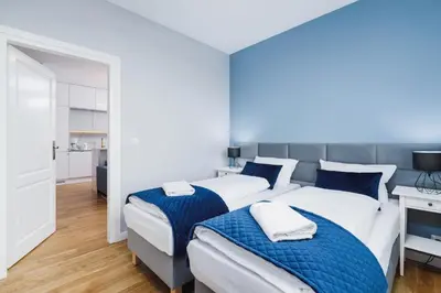 a bedroom with two beds with blue and white sheets at NY Residence Apartments Wrocławska Cracow by Renters Prestige in Kraków
