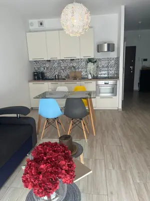 a kitchen with a table with a bouquet of red roses at Way2Stay Browar Lubicz in Kraków