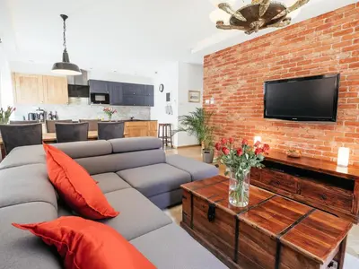 a living room with a couch and a brick wall at Way2Stay Browar Lubicz in Kraków