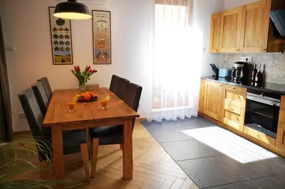 a kitchen with a wooden table with chairs and a dining room at Way2Stay Browar Lubicz in Kraków