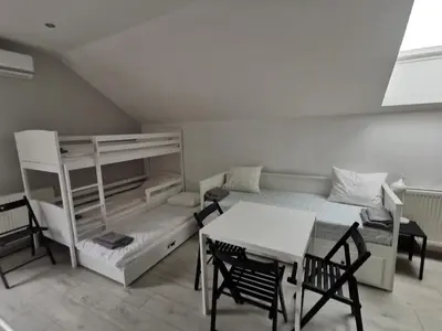 a room with a bunk bed and a table and chairs at Pokoje pod Baranami Zator Przeciszów in Przeciszów