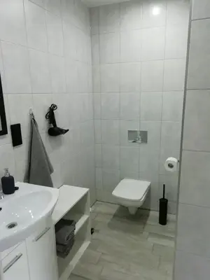 a white bathroom with a sink and a toilet at Pokoje pod Baranami Zator Przeciszów in Przeciszów