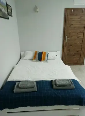 a bed with two towels sitting on top of it at Pokoje pod Baranami Zator Przeciszów in Przeciszów