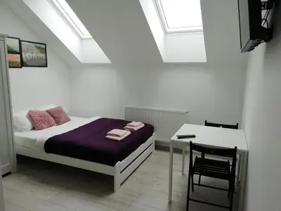 a bedroom with a bed and a desk with a chair at Pokoje pod Baranami Zator Przeciszów in Przeciszów