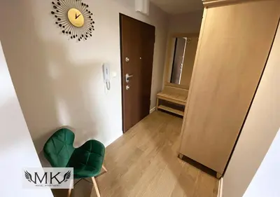 a room with a chair and a mirror on the wall at MK Angel Apartment in Kraków