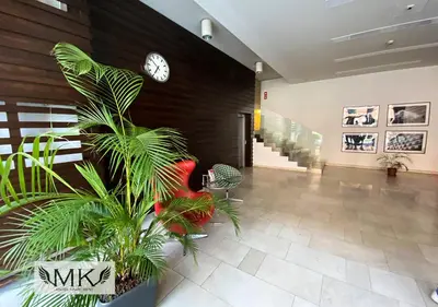 a lobby with a clock on the wall and a plant at MK Angel Apartment in Kraków