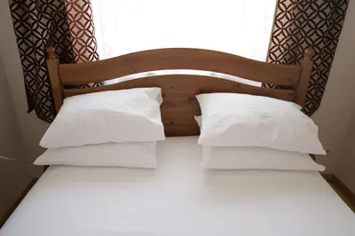 a bed with white pillows and a window at Cosy and Comfortable Apartment in Cracov in Kraków