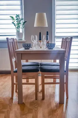 a wooden table with chairs and wine glasses on it at Cosy and Comfortable Apartment in Cracov in Kraków