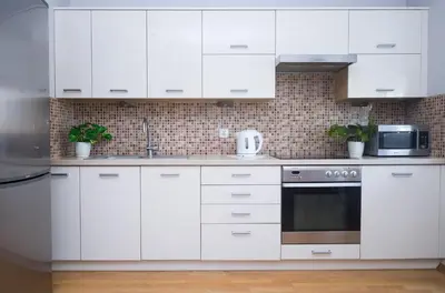a white kitchen with white cabinets and a microwave at Cosy and Comfortable Apartment in Cracov in Kraków