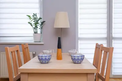 a wooden table with four blue and white bowls on it at Cosy and Comfortable Apartment in Cracov in Kraków