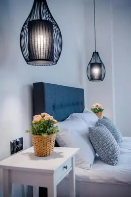 a bedroom with a bed with two pendant lights and a table at GOLDEN ROOMS blisko Energylandii in Zator