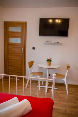 a living room with a table and a tv on the wall at GOLDEN ROOMS blisko Energylandii in Zator
