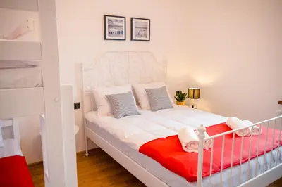 a bedroom with a white bed with a red blanket at GOLDEN ROOMS blisko Energylandii in Zator