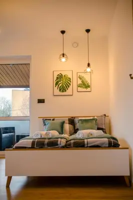 a bedroom with a bed with two pendant lights at GOLDEN ROOMS blisko Energylandii in Zator
