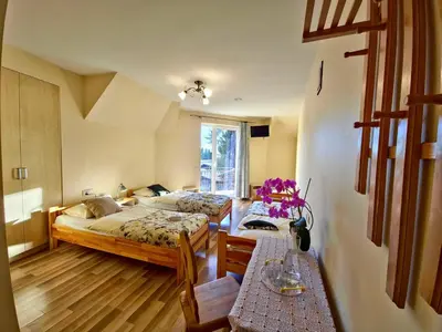 a bedroom with two beds and two tables at U Zosi in PyzÃ³wka