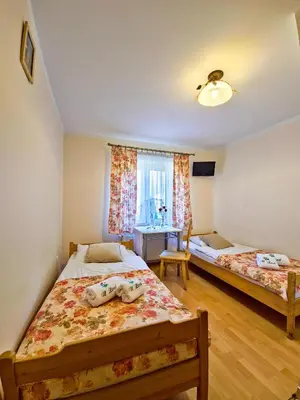 a bedroom with two beds and a window at U Zosi in PyzÃ³wka