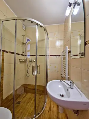 a bathroom with a glass shower and a sink at U Zosi in PyzÃ³wka