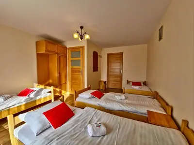 a room with three beds in it at U Zosi in PyzÃ³wka