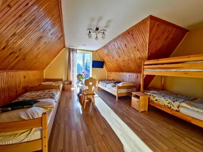 a bedroom with two bunk beds and wooden walls at U Zosi in PyzÃ³wka