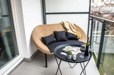 a wicker chair sitting on a balcony with a table at Augustiańska in Kraków