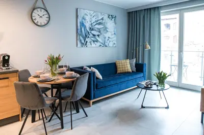 a living room with a blue couch and a table at Augustiańska in Kraków