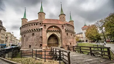 a large brick building with towers on top of it at Discover Krakow Apartments - 3 Rakowicka St - Amazing Loft near Main Station - Netflix in Kraków