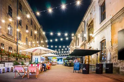 a street with tables and chairs and lights at Discover Krakow Apartments - 3 Rakowicka St - Amazing Loft near Main Station - Netflix in Kraków