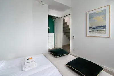 a bedroom with a bed and a painting on the wall at Duplex apartment in the center of Krakow in Kraków