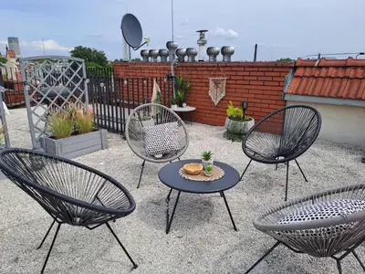a patio with three chairs and a table with a plate of food at Duplex apartment in the center of Krakow in Kraków