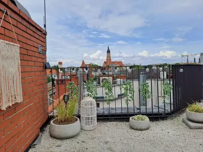 a garden with plants in pots next to a fence at Duplex apartment in the center of Krakow in Kraków