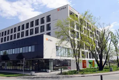 a large white building with a tree in front of it at APARTAMENT LIPSKA 4 in Kraków