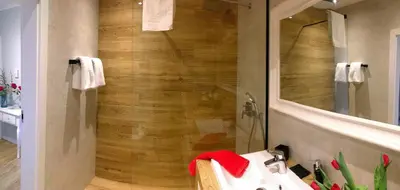 a bathroom with a shower with a sink and a mirror at APARTAMENT LIPSKA 4 in Kraków