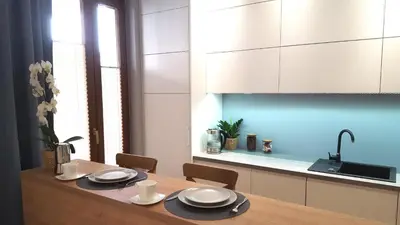 a kitchen with a wooden table and white cabinets at Julia Apartments Rakowicka - Old Town in Kraków