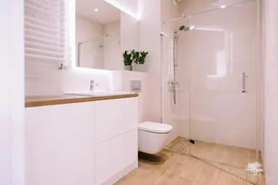 a white bathroom with a toilet and a shower at Julia Apartments Rakowicka - Old Town in Kraków