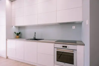 a white kitchen with a sink and a stove at Julia Apartments Rakowicka - Old Town in Kraków