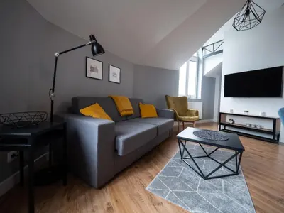 a living room with a gray couch and yellow pillows at Old Town Apartment Morsztynowska in Kraków