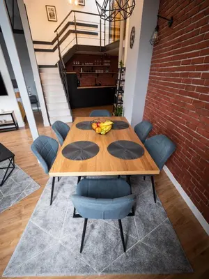 a dining room with a wooden table and blue chairs at Old Town Apartment Morsztynowska in Kraków