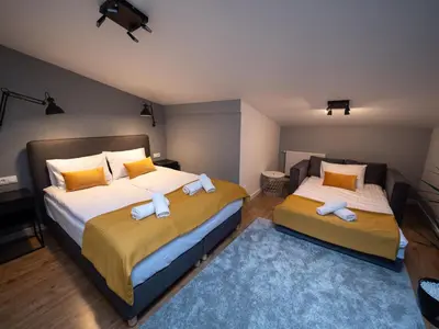 a bedroom with two beds and a blue rug at Old Town Apartment Morsztynowska in Kraków