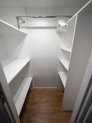 a walk in closet with white shelves at Old Town Apartment Morsztynowska in Kraków