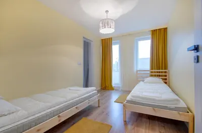a room with two beds and a large window at Apartment Kordiana in Kraków