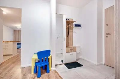 a room with a table and a blue chair at Apartment Kordiana in Kraków